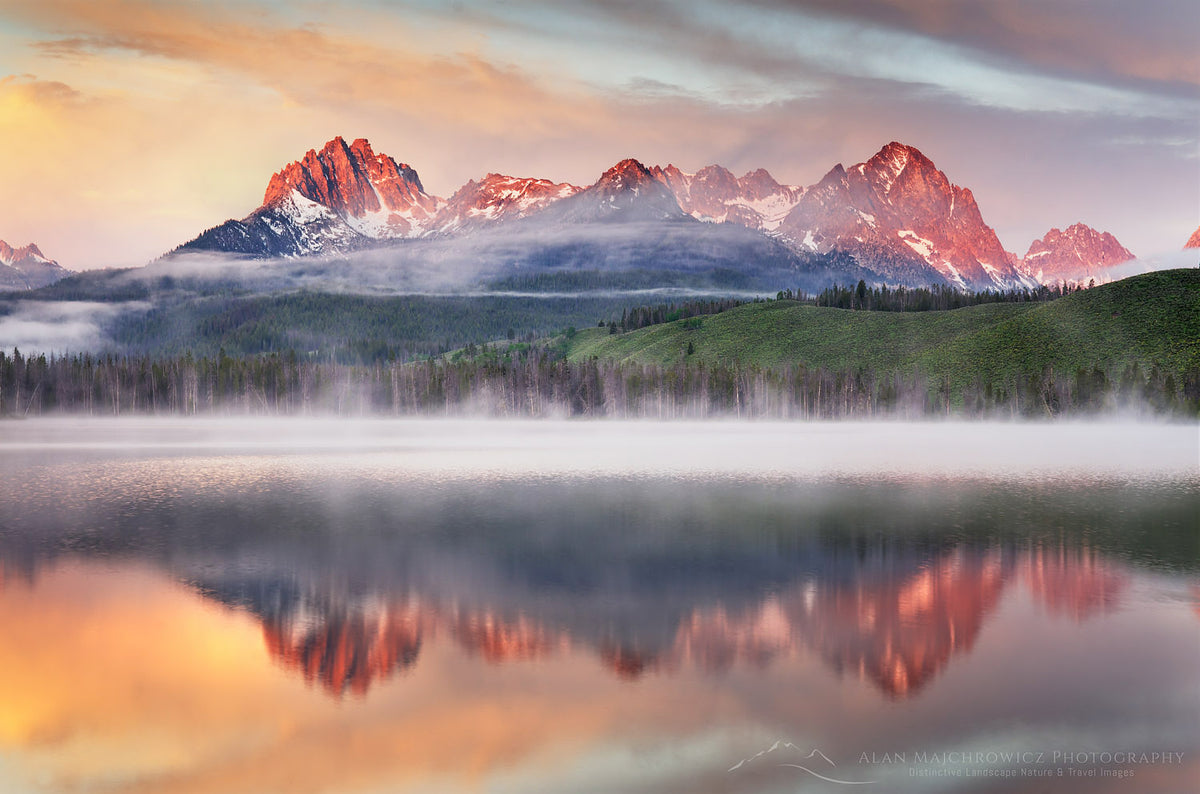 The Sawtooth Range near Stanley at first light, mirrored in a still mountain lake.